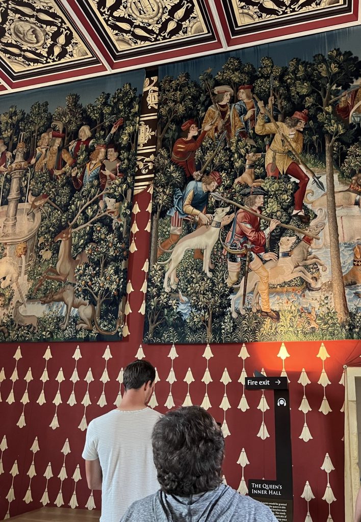 Continuing around the room, the wallpaper continues along with more panels of the tapestries. Now the ceiling is visible with brightly pained panels in the same colors as the tapestreis and the wallpaper.