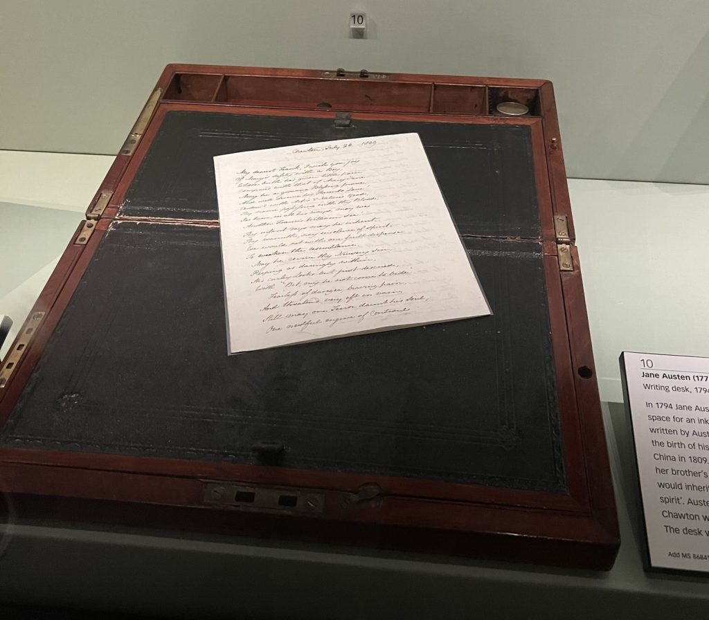 Small foldable writing desk belonging to Jane Austen with a letter from her to her brother. The desk has an ink well and places for pens. The writing surface looks to be leather with a wooden frame.