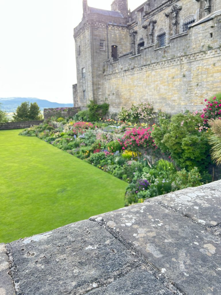 View of the garden looking out the north end of the castle with the highland mountains in the background. 