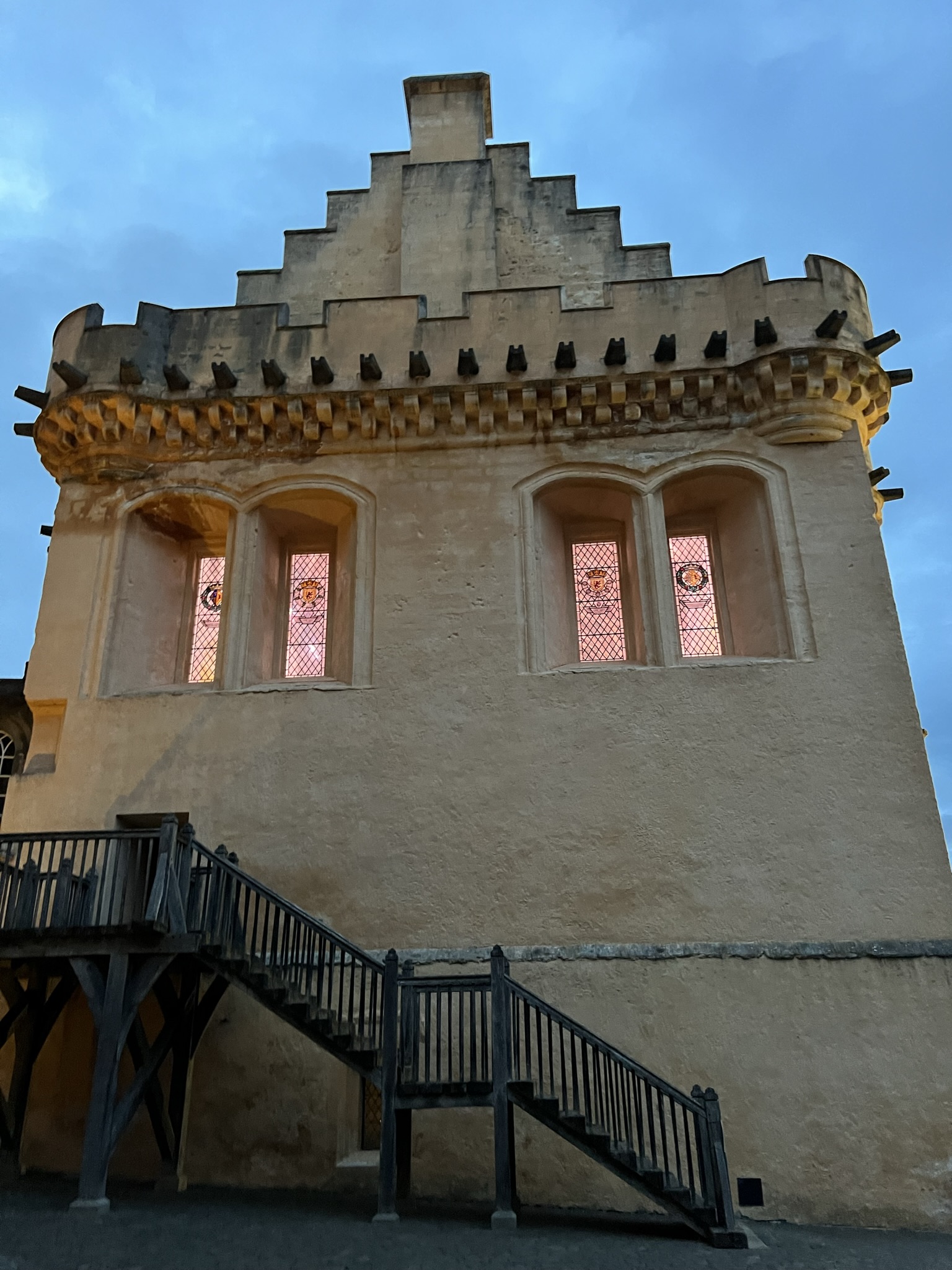 Great Hall at dusk with the light coming from inside.  The bright yellow paint seems to glow in the night sky.
