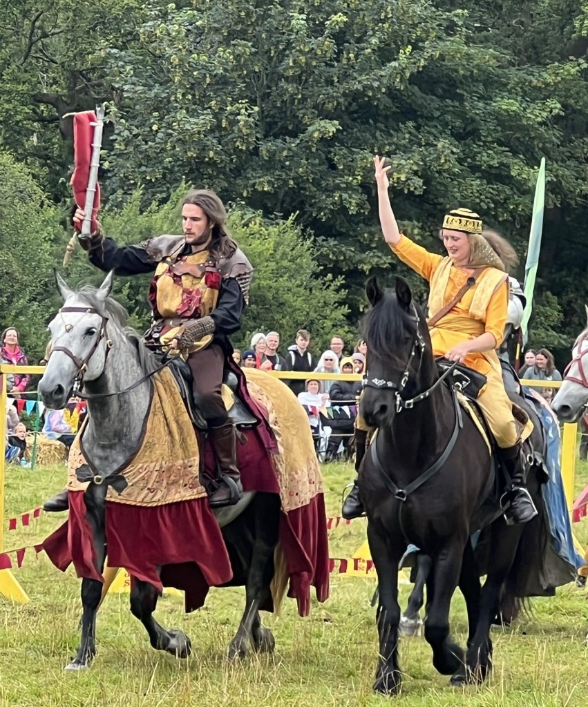 A knight and the fair maiden riding their horses together at the end of the joust.