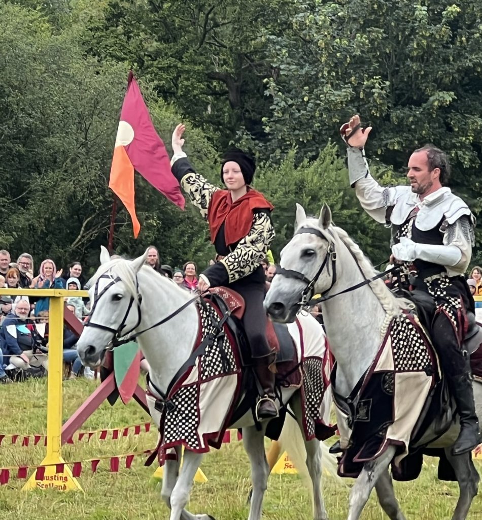 The squire and the knight - both on white horses. They are saluting the crowd at the end of the joust.