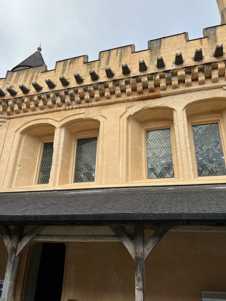 The entry to the great hall with the upper windows displayed above the porch-like covering.